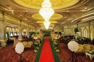 a large banquet hall with a red carpet and chairs at Grand Qin Hotel Syariah in Martapura +233 photos