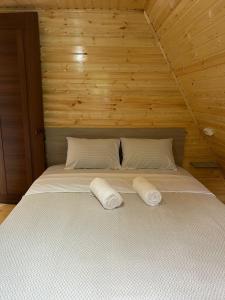 a large bed in a wooden room with two pillows at Sunny House Buknari in Buknari