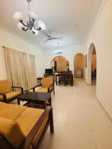una sala de estar con sofá, mesas y sillas en 2 BHK Appartment calangute, en Calangute