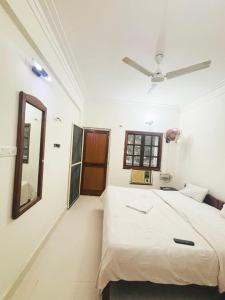 Un dormitorio con una cama y un ventilador de techo. en 2 BHK Appartment calangute, en Calangute