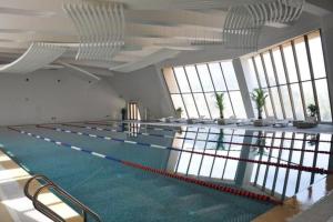 a large swimming pool in a building with windows at CITIC Jinling Hotel in Xiyu