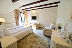 ein Hotelzimmer mit einem Bett und einem Wohnzimmer in der Unterkunft Natura Family Resort in Avrig