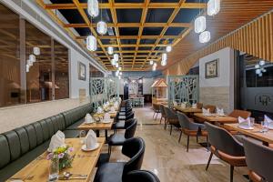 een restaurant met houten tafels en stoelen bij Hays AIR By Ahuja Residences - Golf Course Ext Road & Sector 51 in Gurgaon