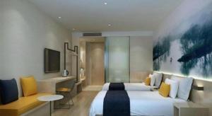 ein Hotelzimmer mit einem Bett und einem Fernseher in der Unterkunft Ibis Styles Shanghai Qingpu Sports Center Hotel in Qingpu