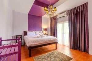 um quarto com paredes roxas, uma cama e um lustre em V265 2BR Pool Villa Near Fitness Gyms Muay Thai em Ban Saiyuan (1) mais 28 fotografias