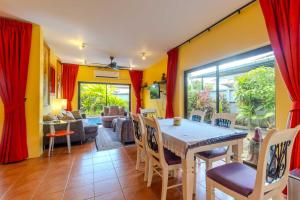 uma sala de jantar com mesa e cadeiras em V265 2BR Pool Villa Near Fitness Gyms Muay Thai em Ban Saiyuan (1)