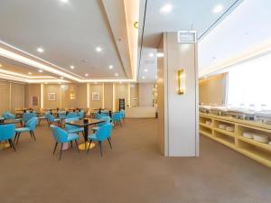 ein Esszimmer mit Tischen und blauen Stühlen in der Unterkunft GreenTree Eastern Dali Railway Station Hotel in Dali