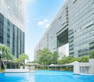 a swimming pool in front of a tall building at Orchard Scotts Residences by Far East Hospitality in Singapore