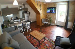 un soggiorno e una cucina con divano e tavolo di Maisoun Pequeux ad Arromanches-les-Bains