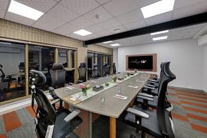 een grote conferentieruimte met een lange tafel en stoelen bij Hays AIR By Ahuja Residences - Golf Course Ext Road & Sector 51 in Gurgaon +38 foto's