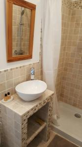 W łazience znajduje się biała umywalka i prysznic. w obiekcie Maisoun Pequeux w mieście Arromanches-les-Bains