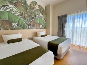 a hotel room with two beds and a large window at Solea Seaview Resort in Mactan