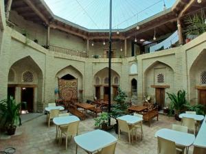 an empty patio with tables and chairs in a building at Aist Hotel Bukhara in Bukhara