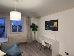 ein Wohnzimmer mit einem weißen Schreibtisch und einem Tisch in der Unterkunft PanoramaOase - stilvoll & ruhig - 75qm in Halle an der Saale
