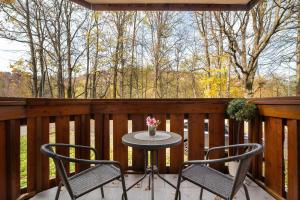 a patio with two chairs and a table on a deck at Charming Studio with Parking and Balcony in Karpacz by Noclegi Renters in Karpacz