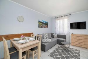 a living room with a couch and a table at Charming Studio with Parking and Balcony in Karpacz by Noclegi Renters in Karpacz