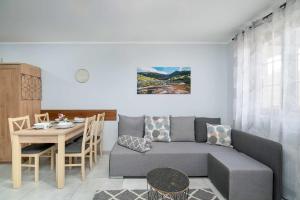 a living room with a couch and a table at Charming Studio with Parking and Balcony in Karpacz by Noclegi Renters in Karpacz