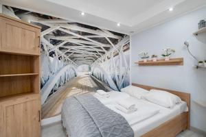 a bedroom with a bed with a mural of a bridge at Charming Studio with Parking and Balcony in Karpacz by Noclegi Renters in Karpacz