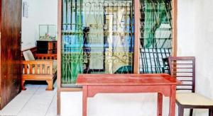 a room with a table and chairs and a window at SPOT ON 93475 Garuda Homestay Syariah in Sukabumi
