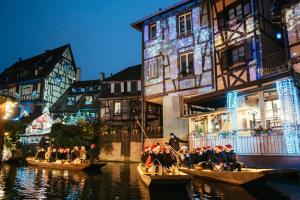 a group of people on boats in the water near buildings at Christmas in Alsace 78m² house Near Colmar in Bollwiller