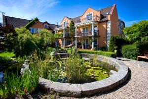 a house with a pond in front of a house at Willa Meander in Łeba