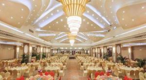 ein großer Bankettsaal mit weißen Tischen und Stühlen in der Unterkunft Cinese Hotel Dongguan in Dongguan