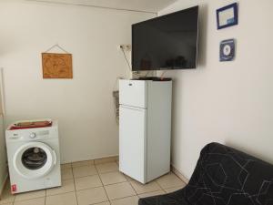 sala de estar con TV en la parte superior de una nevera en Residence Virginie, en Saint-Leu