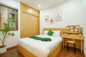a bedroom with a bed and a wooden desk and a table at XÔI Setai Suites Linh Lang in Hanoi +63 photos