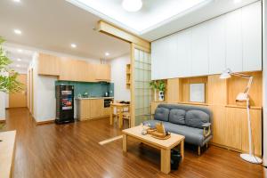 a living room with a couch and a table at XÔI Setai Suites Linh Lang in Hanoi