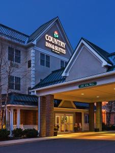 un hotel con un cartel que lee las suites rurales en Country Inn & Suites by Radisson, Lewisburg, PA en Lewisburg