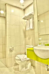 un baño con inodoro y lavabo en Pomelotel Patra Kuningan Jakarta, en Yakarta
