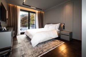 ein Schlafzimmer mit einem weißen Bett und einem großen Fenster in der Unterkunft Villa Rossa Luxury & Spa Residence in Narechenski Bani + 47 Fotos