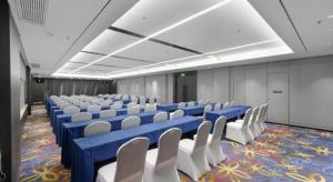 une salle de conférence avec des tables bleues et des chaises blanches dans l'établissement Nanning Sanzan Hotel, à Nanning