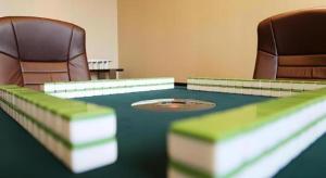 Zimmer mit 2 Stühlen und einem Tisch mit einem Ping in der Unterkunft Jiuhua Jin Jiang International Hotel in Zhenjiang