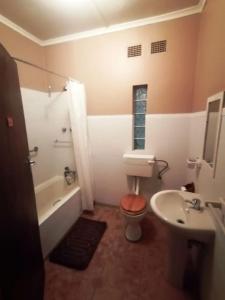 Un baño con bañera, inodoro y lavabo. en Green Trees Cottage, en Nelspruit 9 fotos más
