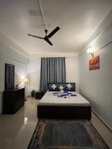 a bedroom with a bed with a ceiling fan at Puhor Inn in Sivasagar