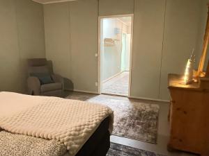 um quarto com uma cama e uma porta com uma cadeira em Raanu Apartments em Raanujärvi mais 21 fotografias