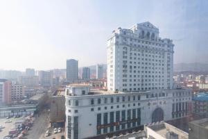 ein großes weißes Gebäude mitten in einer Stadt in der Unterkunft Jinjiang Inn Weihai Liugong Island Scenic Spot Shopping Market in Weihai