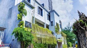 a blue and white building with ivy on it at OYO Life 91205 Rindang Guesthouse Syariah in Karawang