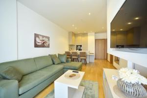 Una sala de estar con un sofá verde y una mesa. en Budva Wow Apartments, en Budva