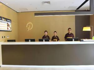 eine Gruppe von Menschen, die an einer Theke sitzen in der Unterkunft IU Hotel Tianjin Fumin Qiao Branch in Tianjin