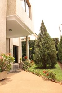 a christmas tree in a garden in front of a building at Hotel Residence Flamani in Lomé