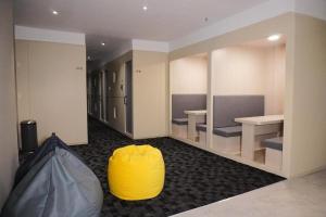una habitación con un puf amarillo y mesas en NapzBox, en Petaling Jaya