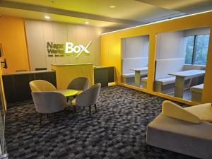 una sala de espera con escritorio, sillas y mesa en NapzBox, en Petaling Jaya