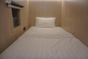 Cama blanca en habitación pequeña con ventana en NapzBox, en Petaling Jaya 12 fotos más