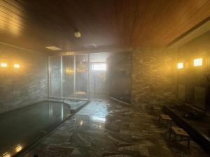 Zimmer mit einer Badewanne in einer Steinwand in der Unterkunft Hotel Obokekyo Mannaka in Miyoshi