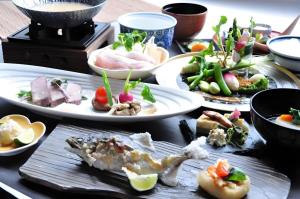 ein Tisch mit Tellern voller Essen darauf in der Unterkunft Hotel Obokekyo Mannaka in Miyoshi