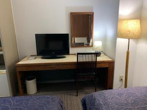 une pièce avec un bureau, une télévision et une chaise dans l'établissement Fujino Kinjo, à Shimo-yoshida