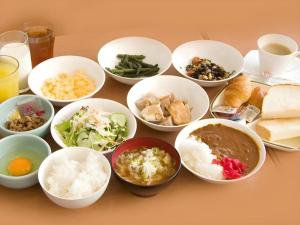 una mesa cubierta con cuencos de diferentes tipos de alimentos en Hotel Park Inn Toyama, en Toyama