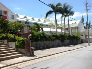 an empty street with a building and palm trees at Petit Hotel Key West Club in Inbu